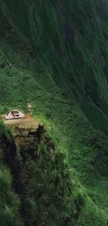 Camping tent on a lush green mountain cliff with breathtaking views.