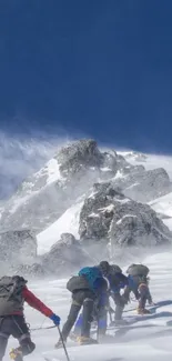 Climbers ascend snowy mountain slopes under clear blue skies.