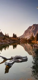 Serene mountain lake with dusk sky and moon reflecting on water.