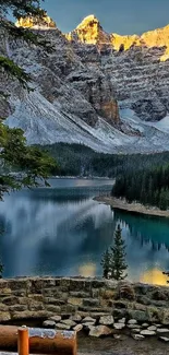 Scenic mountain lake view with golden peaks and calm water at sunrise.