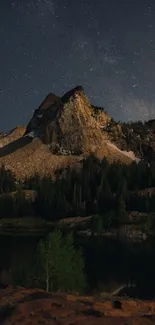 Majestic mountain under starry night sky with trees in foreground.