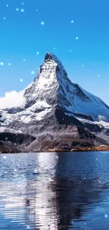 Snow-capped mountain reflecting in tranquil waters under a clear blue sky.