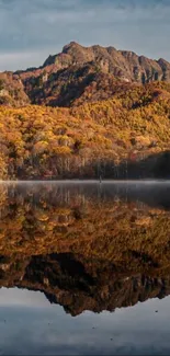 Mountain landscape with reflection in calm lake waters during autumn.