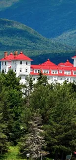 Scenic view of a red-roofed building nestled in lush green mountains.