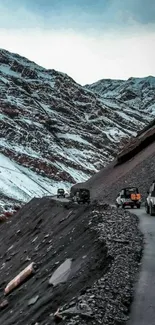 Off-road SUVs on snow-dusted mountain road, stunning landscape.