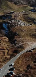 Aerial view of winding mountain road in a rugged landscape.