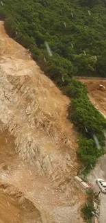 A view of a mountain road construction site with rich earth tones and greenery.