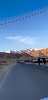 Road winding through mountains at dusk under a blue sky.