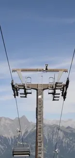 Mountain sky lift with scenic alpine peaks under a clear blue sky.