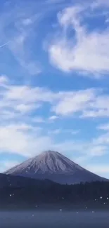 Mountain under blue sky with clouds.