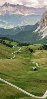 Idyllic mountain valley with winding path and green landscape.