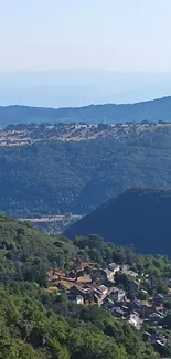 Scenic view of mountain valley with lush greenery and distant sky.