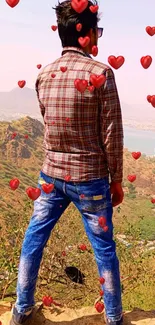 Man standing on mountain overlooking valley with clear sky.