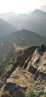 Serene mountain view with sunlit peaks and rugged landscape.