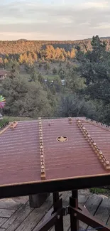 Rustic deck with zither and mountain view in sunset light.