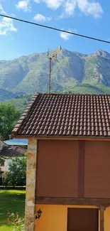 Rustic house with mountain view under a blue sky.