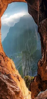 View of mountains through a cave opening with warm brown tones.