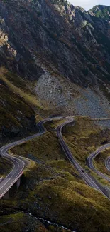 A winding road through scenic mountain terrain under a clear sky.