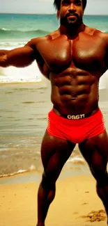 Muscular individual on beach with red shorts.