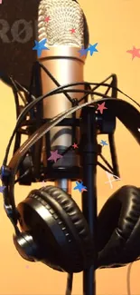 Studio microphone and headphones on an orange background.