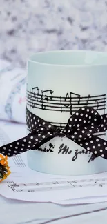 Mug with musical notes and polka-dot ribbon on a table.