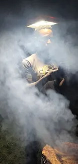 Person grilling in smoke at night garden BBQ.