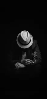 Mysterious figure in hat with cigarette, black and white wallpaper.