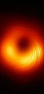 Black hole with an orange swirling glow in space.