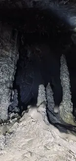 Stalactites in a dark cave with mysterious shadows.