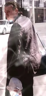 Man in a dark coat with a mysterious atmosphere on city street wallpaper.