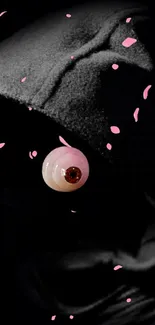 Dark hooded figure with eye and pink petals on black background.