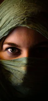 Woman with veil and mysterious eyes in green-themed mobile wallpaper.