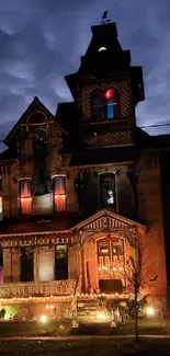 Haunted Victorian mansion illuminated at night.