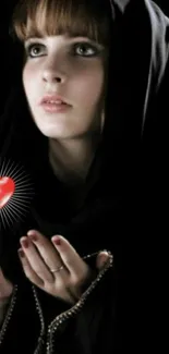 Mysterious woman in hood holding glowing heart.