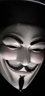 Guy Fawkes mask with a dark background on mobile wallpaper.