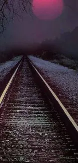 Eerie railway under a red moon night sky.