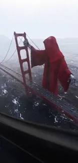 Figure in red cloak stands on stormy bridge, viewed from window.