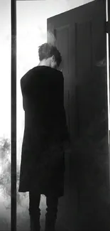 Silhouette of a person behind an open door surrounded by smoke in black and white.