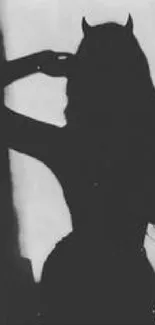 Silhouette of a figure with horns in black and white.