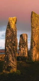 Scottish stone circle under a vibrant sunset sky.