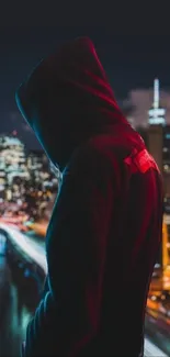 Silhouetted figure overlooking a bright city skyline at night.