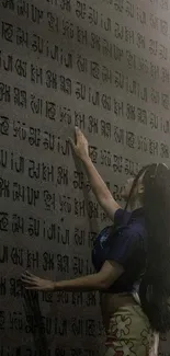 A person touches a wall covered in ancient script, creating a mysterious ambiance.