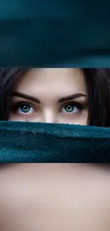 Captivating mobile wallpaper with mysterious green eyes over blue fabric.