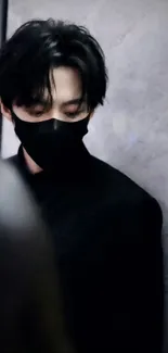 Mysterious figure in black against a marble background, wearing a mask.