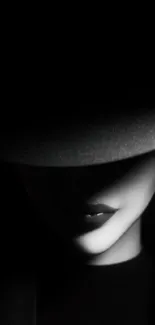 Mysterious woman in shadow with hat creating noir effect on wallpaper.