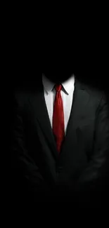 Black suit with red tie against a dark background.