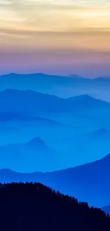 Serene blue mountain range at sunrise with vibrant sky.