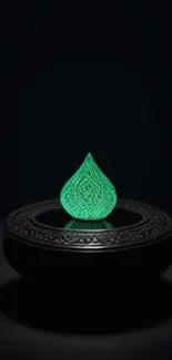 Intricate glowing green teardrop on a dark base.