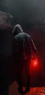 Hooded figure with red light in a dark cave.