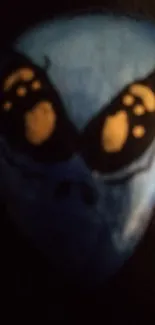 Mysterious blue alien face with golden eyes on dark background.